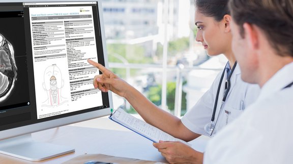 Ein Arzt und eine Ärztin schauen sich einen digitalen strukturierten Befund auf einem PC an