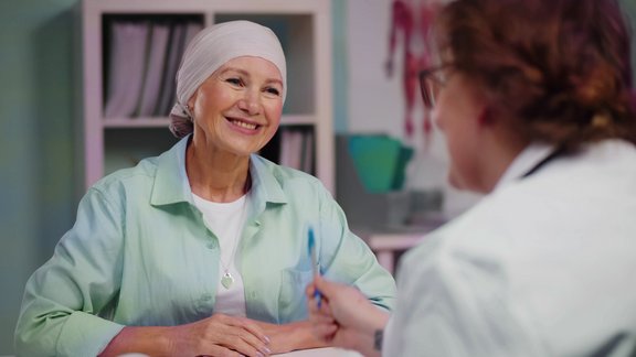 A picture of a cancer patient talking to the doctor who is treating her.